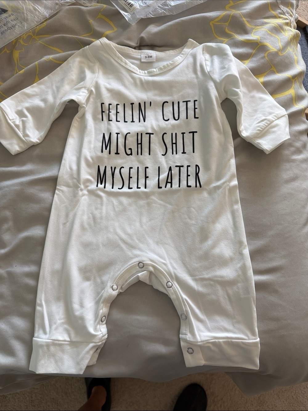 White Baby Romper with Black Text "Feelin' Cute"